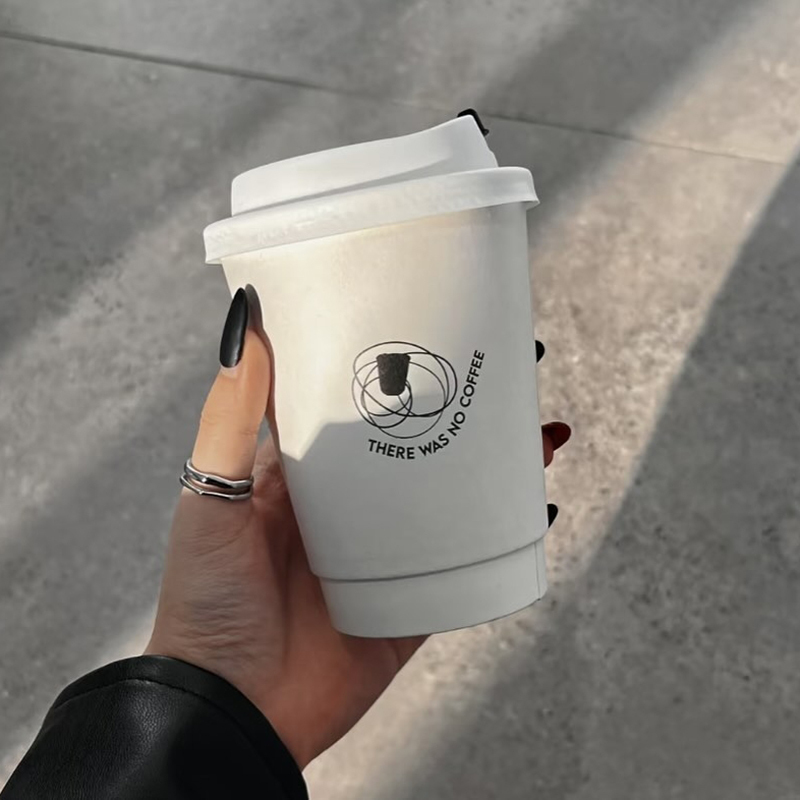 Custom-printed disposable double-wall paper cups for hot drinks—suitable for milk tea and coffee—with lids.