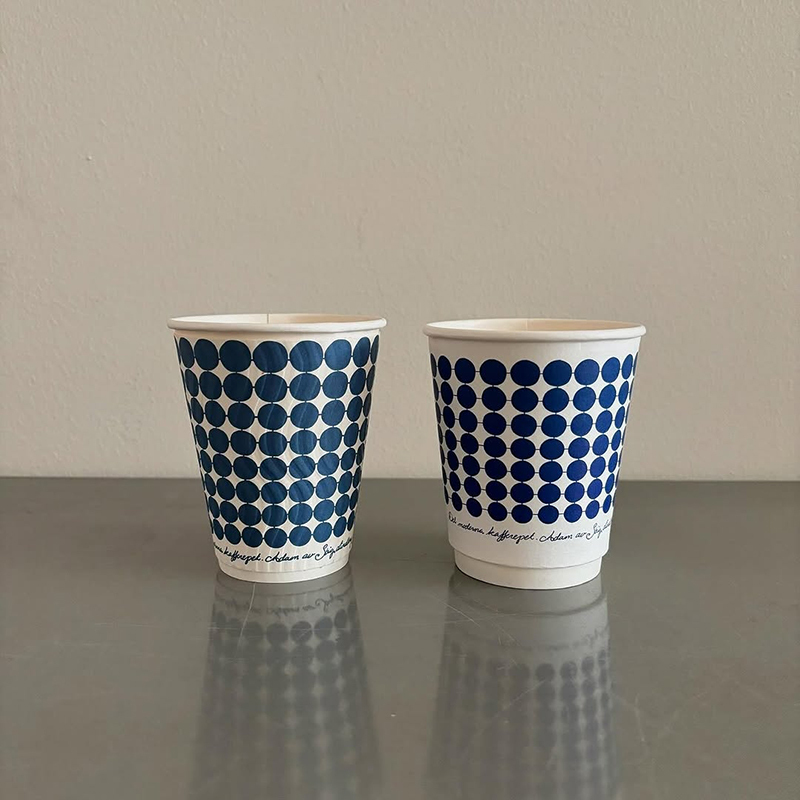 Custom-printed disposable double-wall paper cups for hot drinks—suitable for milk tea and coffee—with lids.