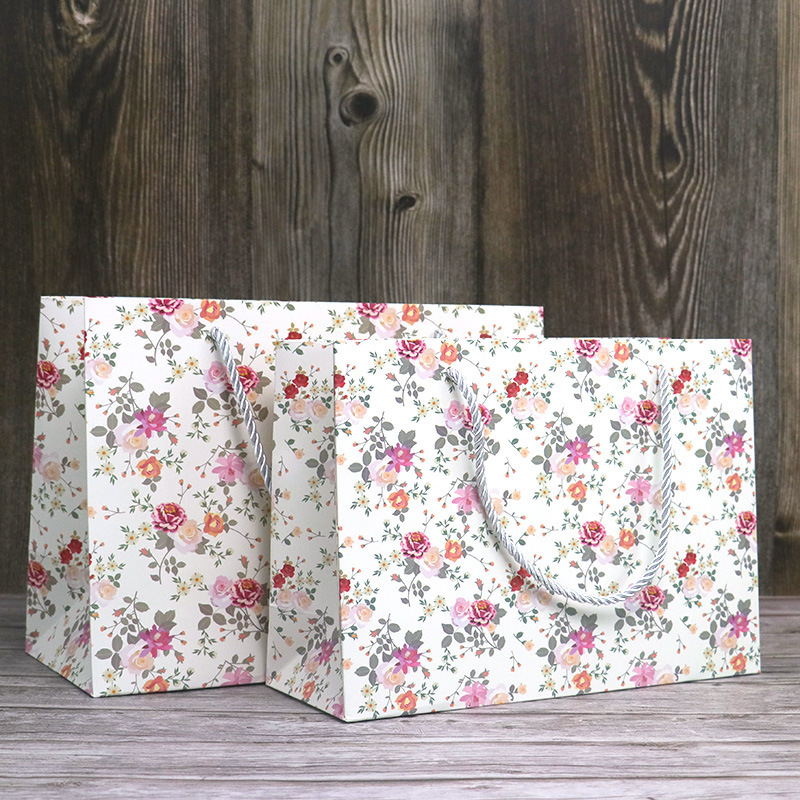 Wholesale minimalist floral-print paper bags  customizable with logos; small-sized shopping bags for gifts and souvenirs.