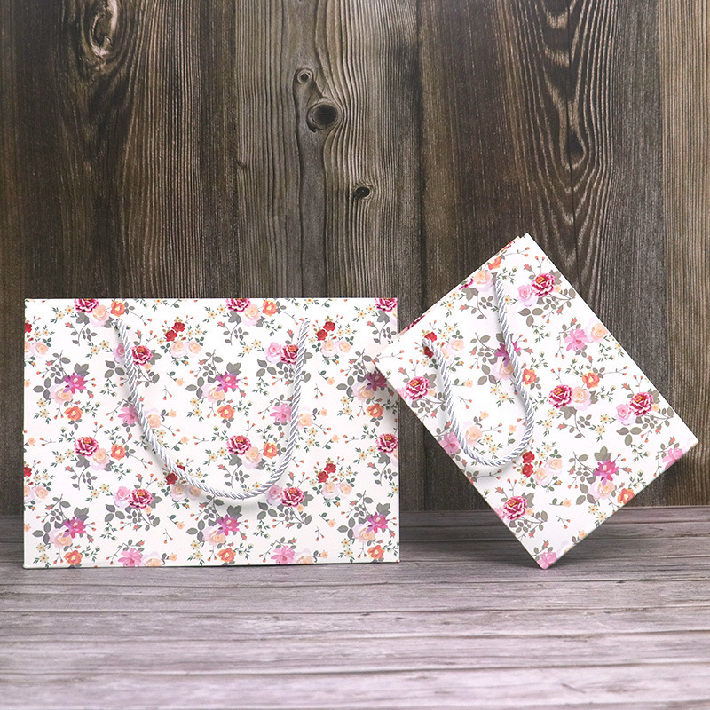 Wholesale minimalist floral-print paper bags  customizable with logos; small-sized shopping bags for gifts and souvenirs.